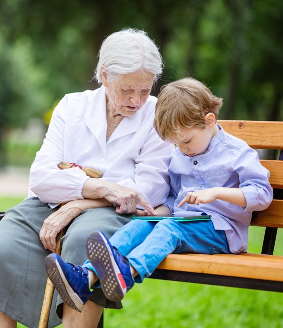 Elderly women works with child on tablet